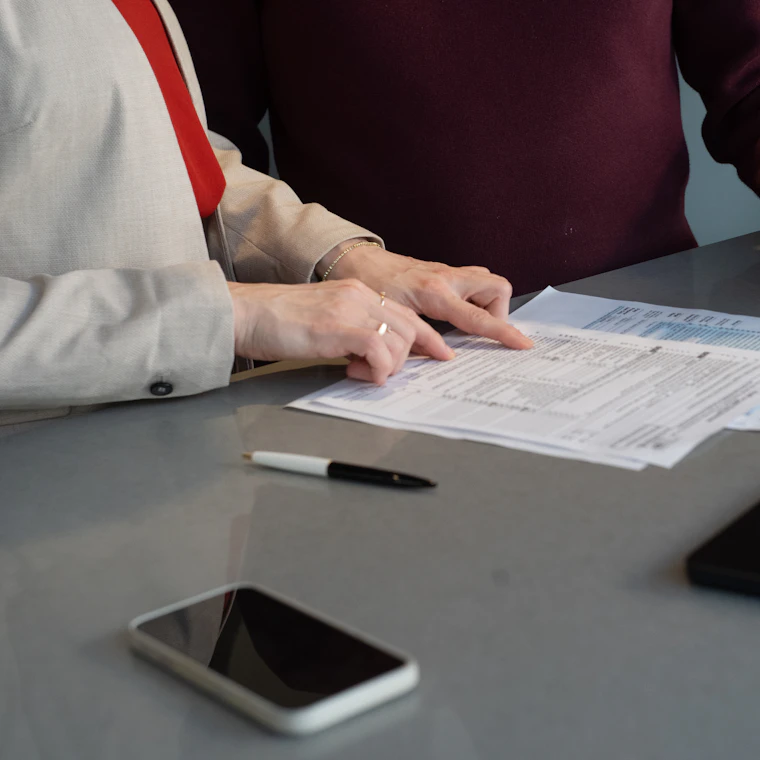 Two colleagues reviewing a financial document together at a desk