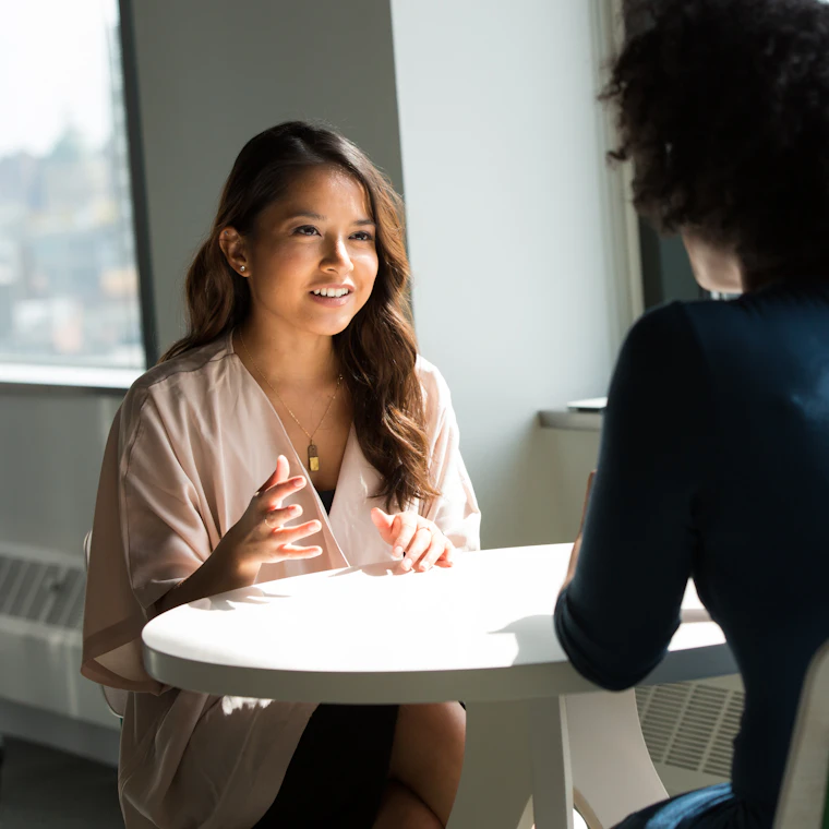 Two colleagues having a supportive one-to-one mentoring conversation