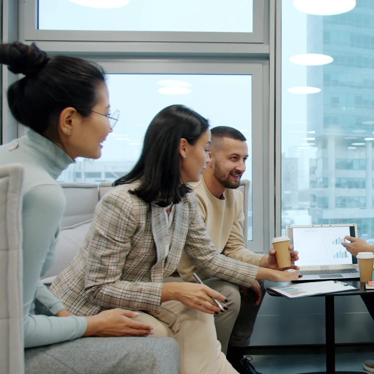 Diverse group of colleagues chatting warmly together near a window