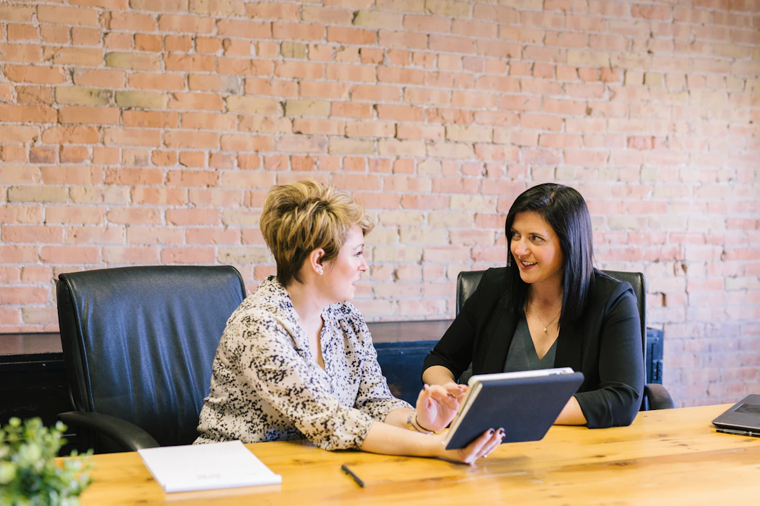 Two professionals in a warm consultation discussion at an office table