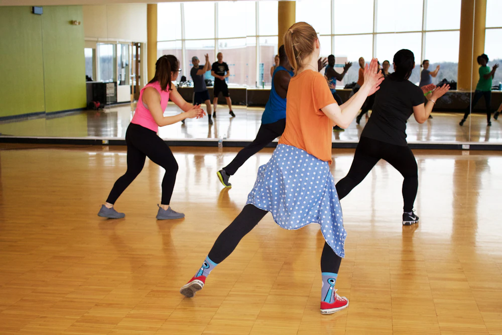 Group dance fitness class moving together in a mirrored studio