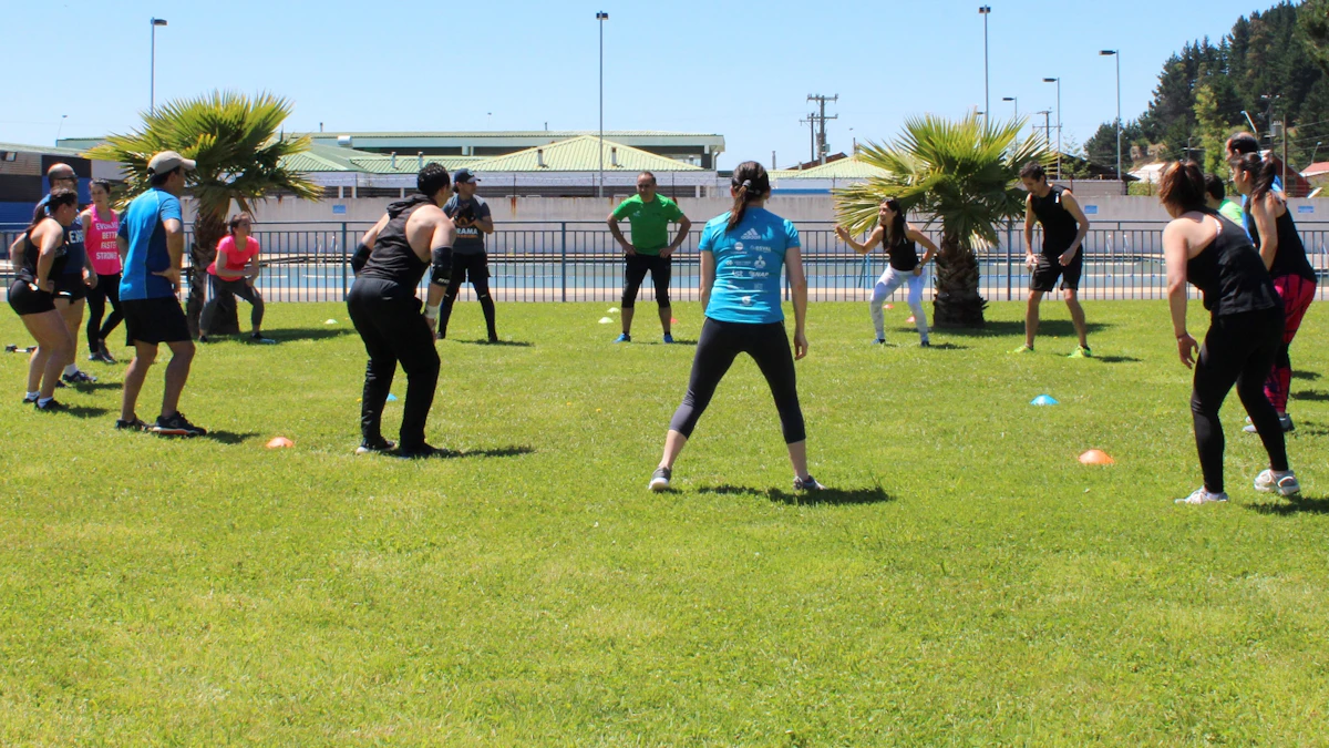 Outdoor group fitness class stretching together on a sunny lawn