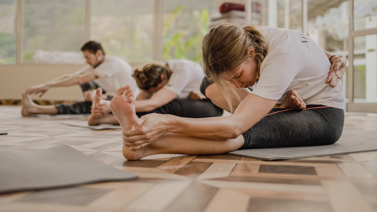 Small group practicing a seated yoga stretch together in a bright studio